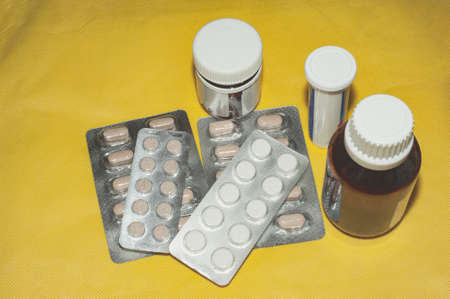 A variety of pills in blisters on a yellow background copy space. Medicinesの写真素材