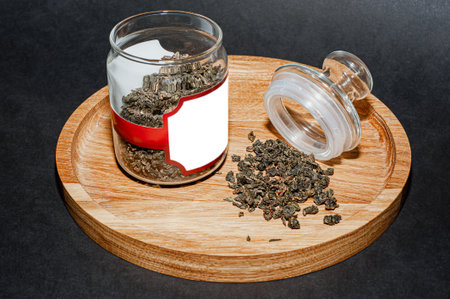 Dry tea with green leaves in wooden spoons, on wooden backgroundの写真素材