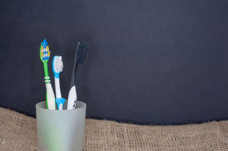 four toothbrushes in different colored glass cups.の写真素材