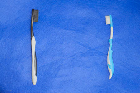 two toothbrushes for adults and children isolated on blue backgroundの写真素材