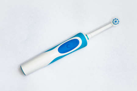 Modern electric toothbrush standing on a white background. Controlled tool for daily oral care.の写真素材