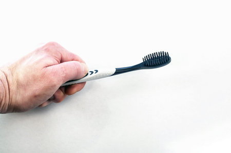 Female hand with toothbrush on white background.