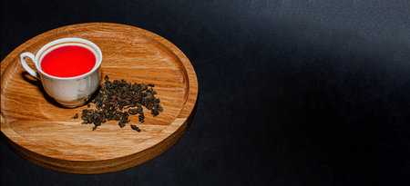 Dry tea with green leaves in wooden spoons, on black backgroundの写真素材
