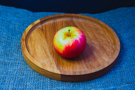 Still life with green apples on a platter on a wooden table.の写真素材