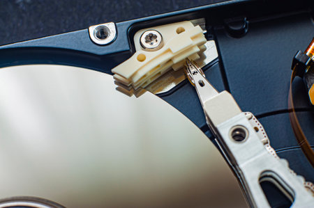 Macro view of an HDD head resting on a disk platter and its reflection.の写真素材