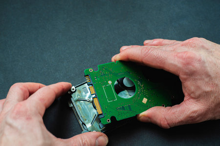Engineer fixing broken computer hard disc. Electronic repair shop, technology development concept.の写真素材