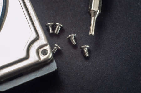 disassembling hard drive to repair with black backgroundの写真素材