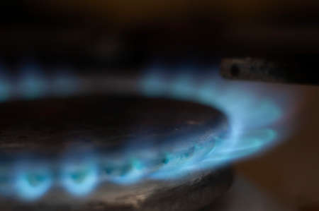 Closeup shot of blue fire from domestic kitchen stove top. Gas cooker with burning flames of propane gas. Industrial resources and economy concept.の写真素材