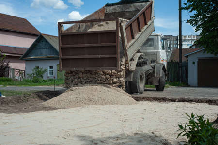 Dump trucks carrying good filling a field, giving rise to a fine soil. Preparation and construction.の写真素材