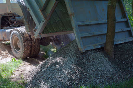 Dump trucks carrying good filling a field, giving rise to a fine soil. Preparation and construction. Cityの写真素材