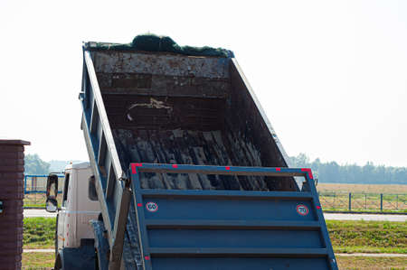 Dump trucks carrying good filling a field, giving rise to a fine soil. Preparation and construction. Cityの写真素材