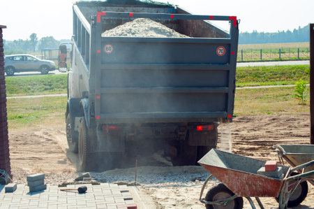 Dump trucks carrying good filling a field, giving rise to a fine soil. Preparation and construction. Cityの写真素材