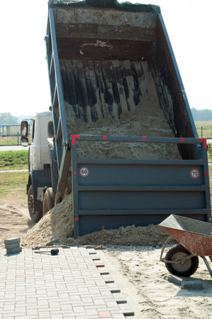 Dump trucks carrying good filling a field, giving rise to a fine soil. Preparation and construction. Cityの写真素材