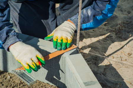 A worker measures a concrete block with a ruler, close-up.の写真素材