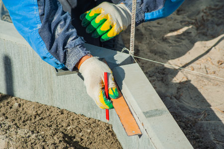 A worker measures a concrete block with a ruler, close-up.の写真素材