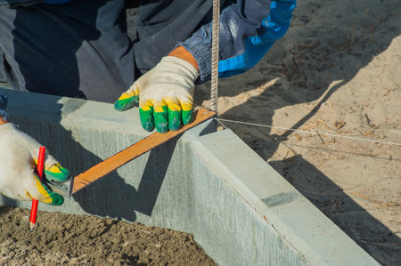 A worker measures a concrete block with a ruler, close-up.の写真素材