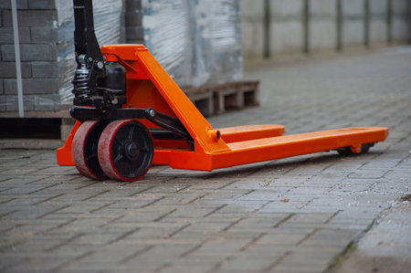 Old orange manual hand pallet trucks. Close up wheel of hydraulic hand pallet truck.の写真素材