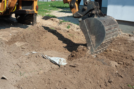 Excavator bucket close-up on the background of a construction site. Heavy earthmoving equipment. Soil development.の写真素材