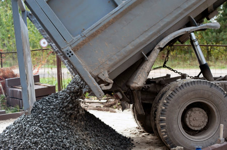 Dump trucks carrying good filling a field, giving rise to a fine soil. Preparation and construction.の写真素材