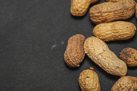 flat lay wave shape of roasted unsalted peanuts, peanuts in skin and peanuts in shell, food...
