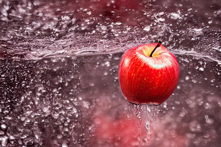 red apple falling into water splashの素材