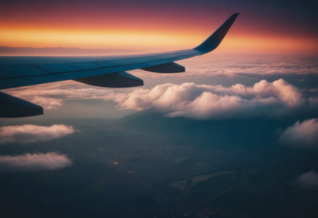 Wing of an airplane flying above the clouds at sunset. Travel conceptの素材