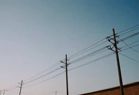 A long row of power lines is meticulously lined up in a vast open field, stretching across the landscape and connecting power sourcesの素材