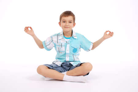 Boy showing yogi, isolated on white backgroundの写真素材