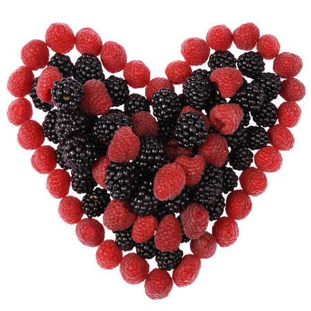 Heart made out of raspberries and blackberries on white backgroundの写真素材