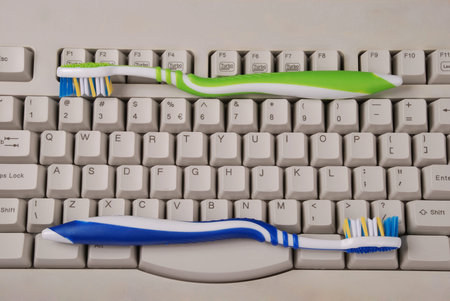 One computer keyboard and toothbrushes. Gray color.の写真素材