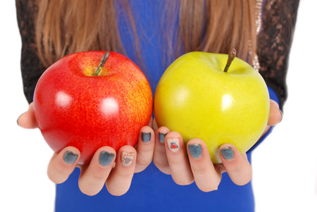 Girl holding a red and green apples isolated on whiteの写真素材