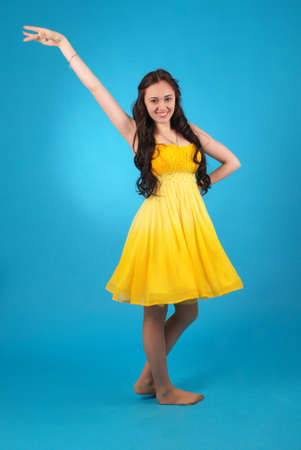 Young girl in ballroom dress on blue studio background.の写真素材