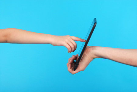 Male hand holding a touchscreen isolated on blue background