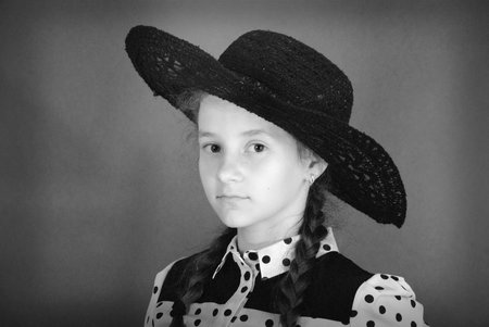 Beautiful young girl in black hat on his head. Black and white imageの写真素材