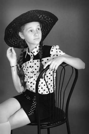 Beautiful young girl in black hat on his head. Black and white image