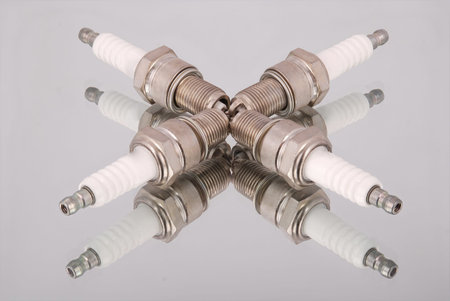 Four new spark plugs on a mirror backgroundの写真素材