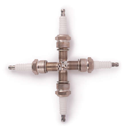 Four new spark plugs on a white background with soft shadowの写真素材