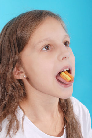 Close up on a beautiful girl while enjoying a chewing gum on blueの写真素材