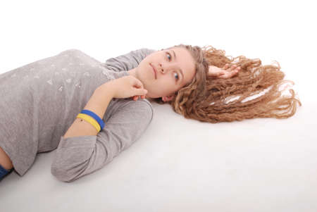 Cheerful young girl are lying against the white backgroundの写真素材