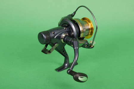 Reel for fishing rods, close up on green backgroundの写真素材