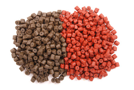 Brown with red pre-drilled halibut pellets for carp fishing isolated on white background with soft...
