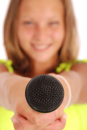 Teenage girl holding a microphone in front. Focus on the microphone. Isolated on white backgroundの写真素材