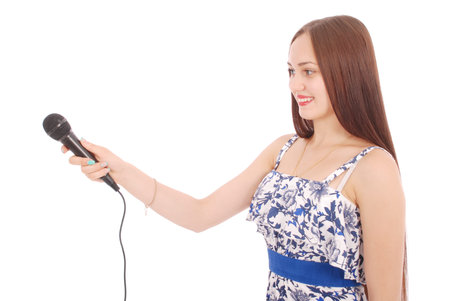 Happy young beautiful girl singing with microphone isolated on white backgroundの写真素材