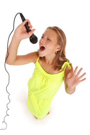 Happy young beautiful girl singing with microphone isolated on white backgroundの写真素材