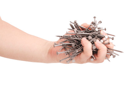 Man's hand holding metal nails. Closeup with clipping path isolated on white backgroundの写真素材