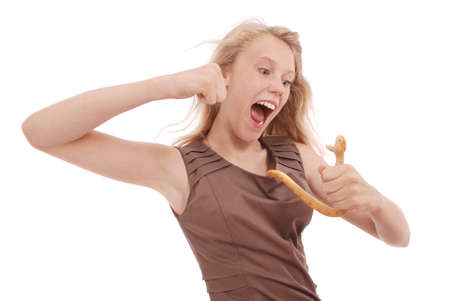 Teenage girl fights with toy snake, simulating  the fear of a snake isolated on whiteの写真素材