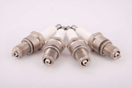Four new spark plugs on a gray backgroundの写真素材