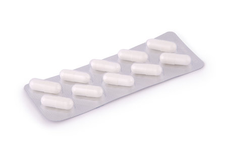Silver blister with pills on white background with soft shadow.