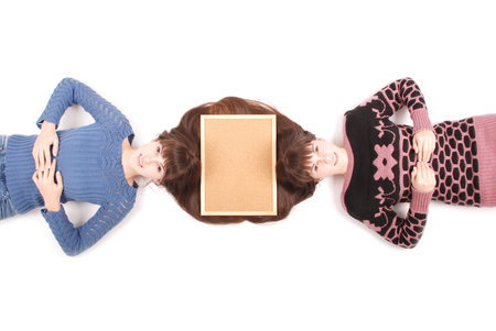 Portrait of two twins sisters with long hair and cork board on the hair, top view on white backgroundの写真素材