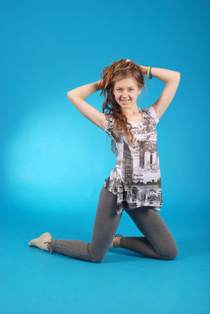 Cheerful young girl are standing against the blue backgroundの写真素材